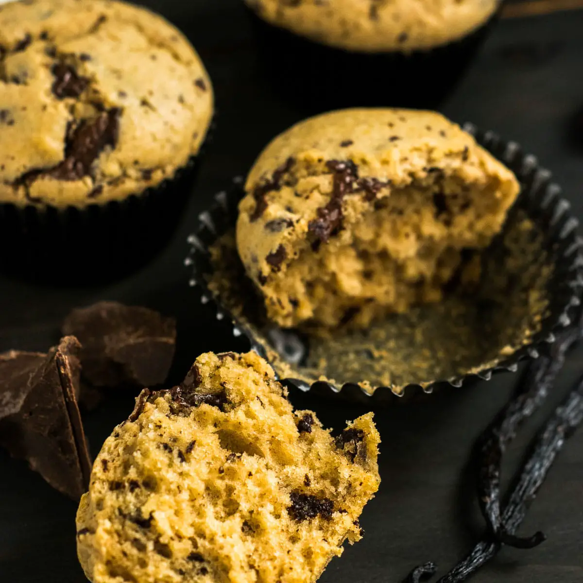 Chocolate Chunk Muffins cut in half showing inside of muffin full of chocolate pieces.