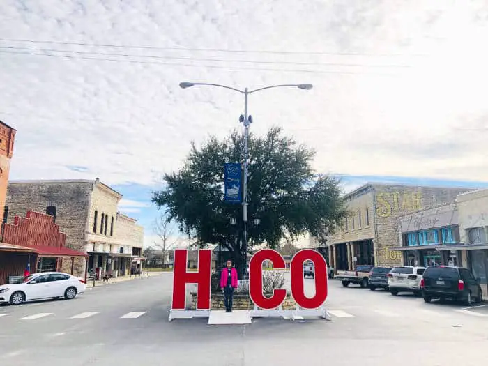 Hico sign with girl standing where the letter I should be