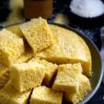 Steamed cornmeal and coconut cake cut in squares on a plate